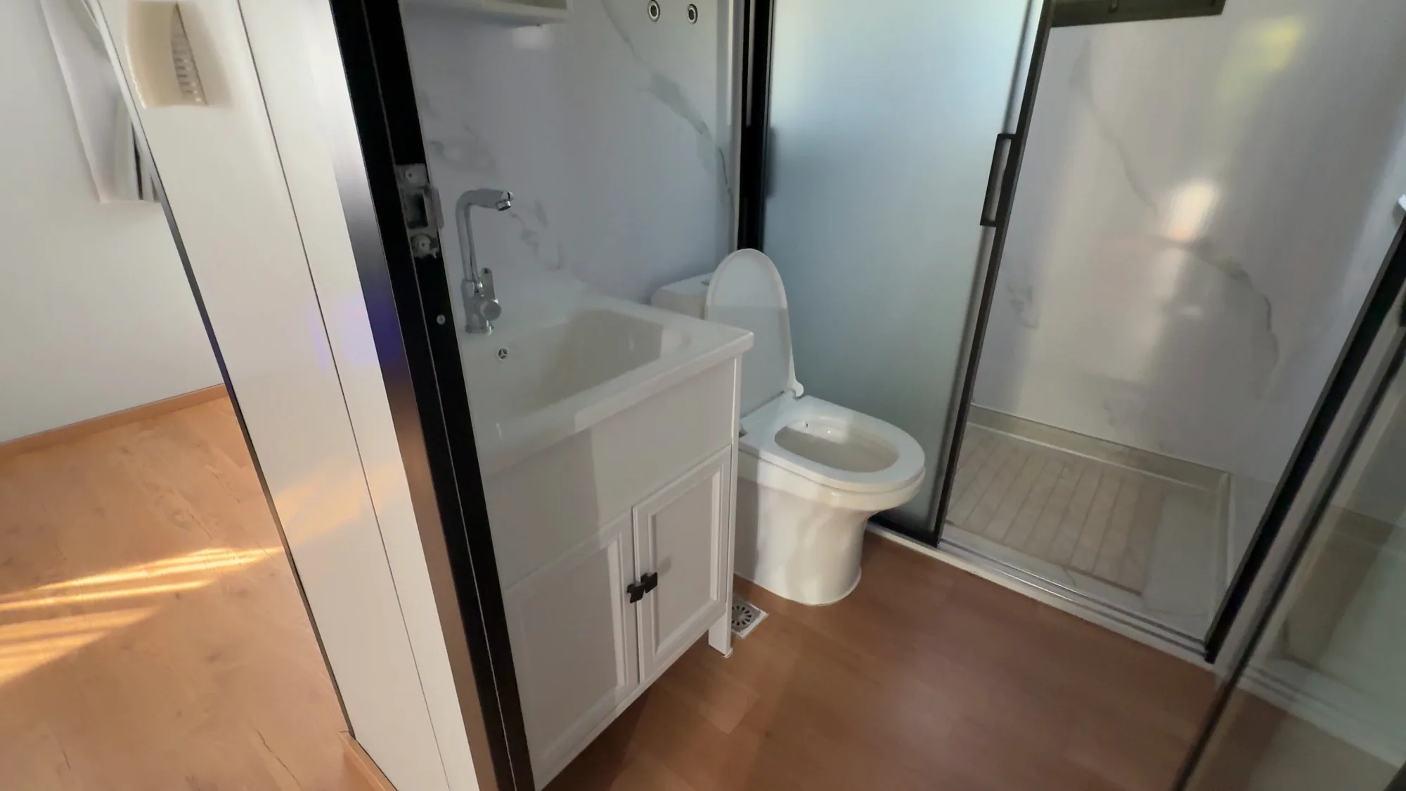 Koupelna se sprchovým koutem, umyvadlem a WC