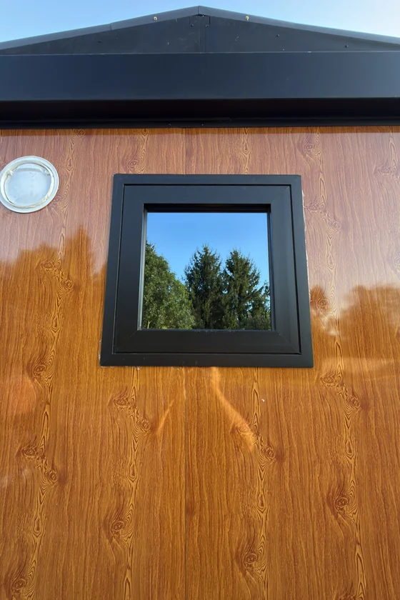 Detail okna v dřevěném fasádním obkladu